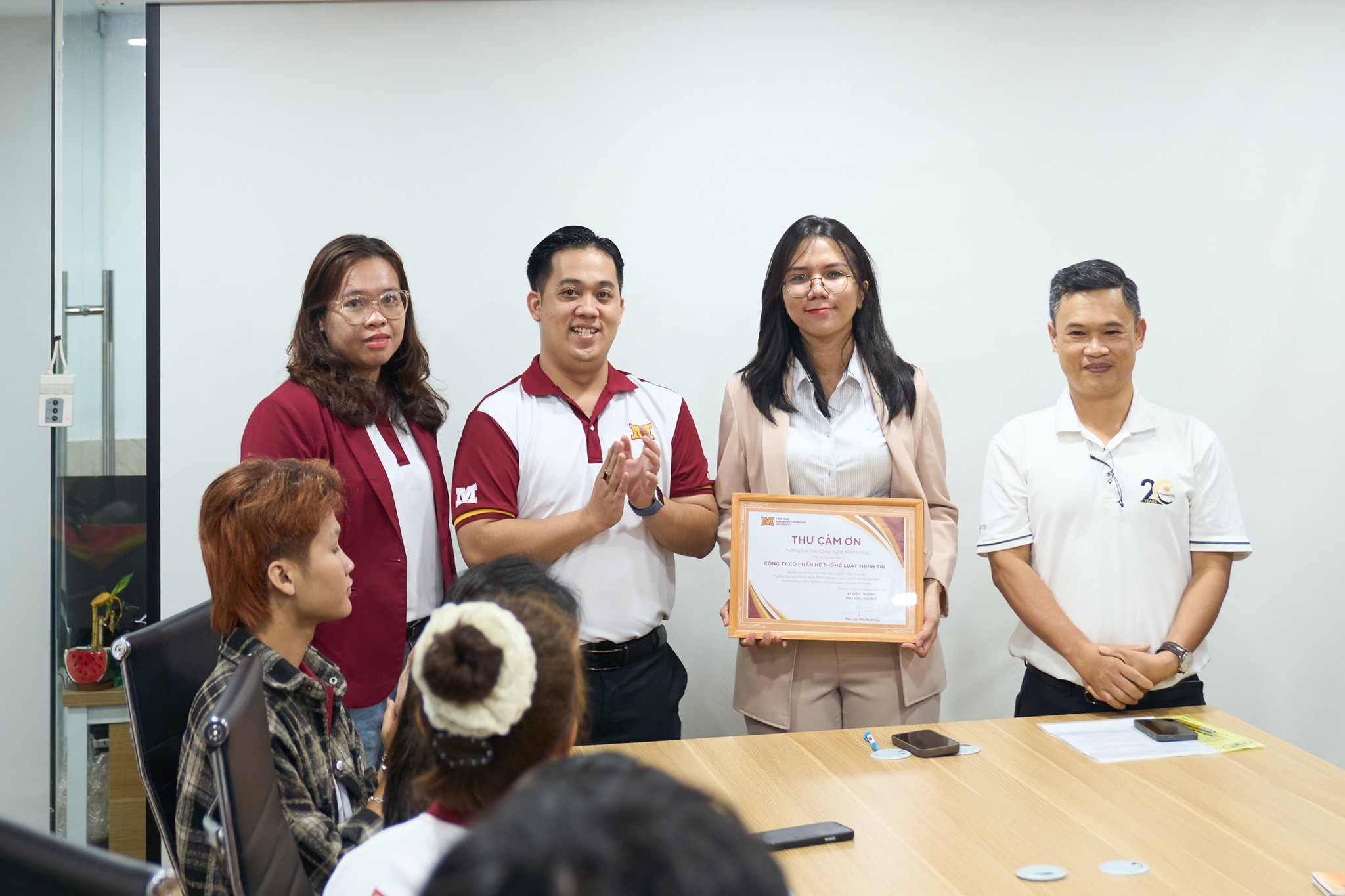 Đại diện Trung tâm Trải nghiệm sinh viên & Quan hệ doanh nghiệp cùng ThS.Ls Mai Thị Ngân Hà - Giám đốc chương trình đào tạo ngành Luật kinh tế tặng thư cảm ơn cho đại diện Hệ thống Luật Thịnh Trí